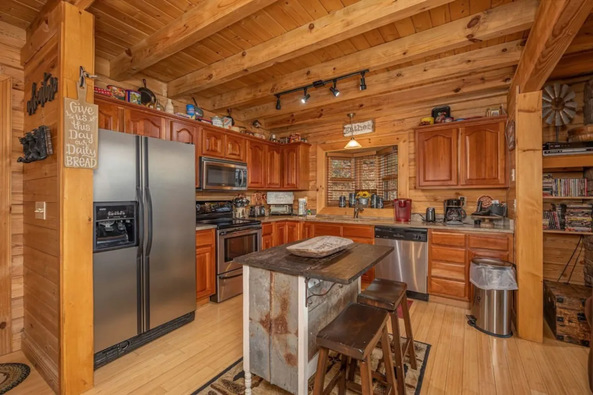A chef-inspired kitchen with stainless steel appliances, wooden cabinetry, and a rustic island, designed for both casual and festive cooking. The open layout encourages interaction while preparing meals, and the space flows naturally into the dining area.